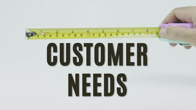 "Customer Needs" text with a tape measure on a white background, symbolizing precision, accuracy, and the concept of tailoring products or services to meet specific consumer demands in a clean video