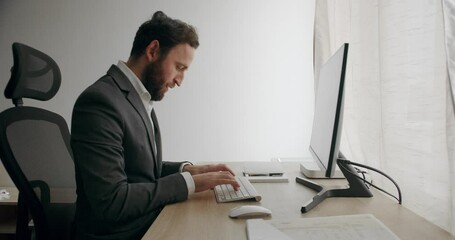Businessman in a gray suit Work at Home. Excited professional reading good news. Happy guy enjoying victory. Young man freelancer in a gray suit using laptop studying working online at home. - Powered by Adobe