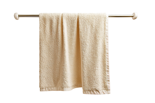 A fluffy beige towel hanging on a silver towel rack against a white background, perfect for bathroom decor.