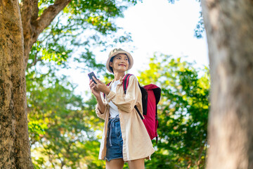 Asian Woman Using Smartphone While Hiking in a Forest Park