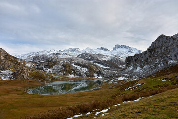 Obraz premium Breathtaking landscape of Lake Ercina with snowy mountains in Asturias, northern Spain
