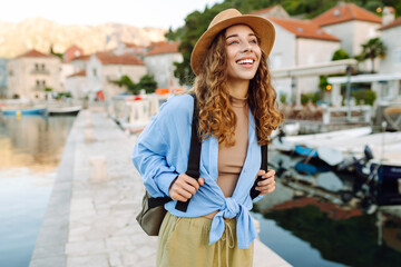 Happy female tourist enjoys the view of the city. Travel, nature, active life