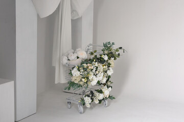 wedding bouquet in white vase. Supermarket trolley decorated with wedding style flowers