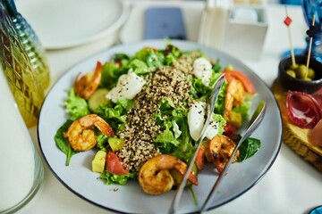 A plate with shrimp, lettuce leaves and avocado. Seafood salad