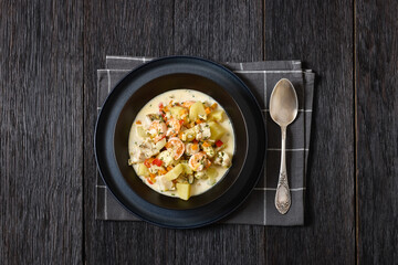 seafood chowder in a white bowl, top view