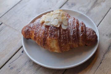 Almond Croissant Bakery homemade on Table. Traditional French breakfast gold crispy croissant. Fresh almond croissant