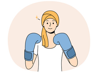 Woman with cancer in boxing gloves symbolizes fight against oncology after chemotherapy. Girl demonstrates desire to live and refuses to give up due to appearance of symptoms of cancer and hair loss