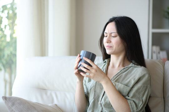 Asian woman complaining about coffee bad taste