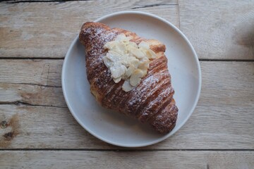 Almond Croissant Bakery homemade on Table. Traditional French breakfast gold crispy croissant. Fresh almond croissant