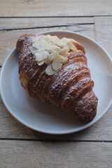 Almond Croissant Bakery homemade on Table. Traditional French breakfast gold crispy croissant. Fresh almond croissant