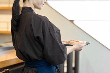 料理を運ぶ和食の従業員