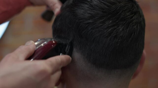 Un homme chez le coiffeur, il se fait tondre les cheveux avec une tondeuse