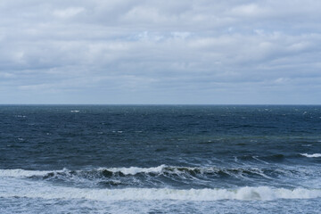 Sea in motion: a captivating view of the Baltic Sea with energetic waves and dramatic clouds in Estonia.