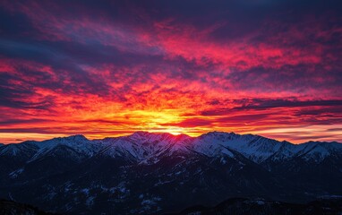 Fototapeta premium Fiery red and orange sunset over a mountain range