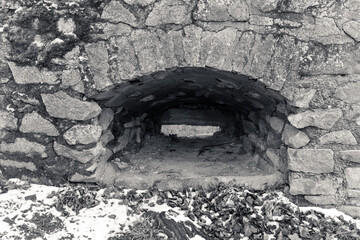 Stone archway reveals interior of historic structure nestled in snowy landscape during winter...