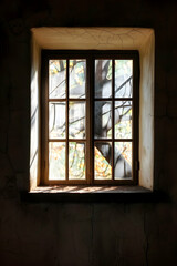 Fototapeta premium A serene window view showcasing vibrant autumn leaves illuminated by soft sunlight