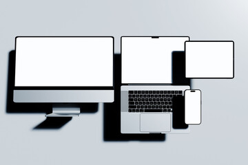 modern electronic devices smartphone, tablet, laptop, and desktop monitor with blank screen for mockup