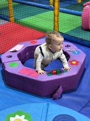 A baby boy playing and having fun in a soft play centre