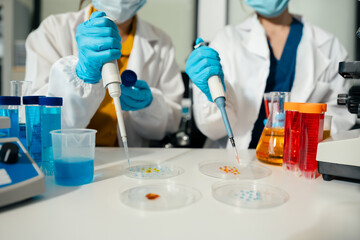 Fototapeta premium Team of biochemical research scientists working with a microscope for vaccine development.