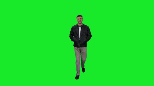Casual mid adult man walking with hands in pockets on green chroma key background, 4k pre-keyed footage
