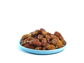 Pile of sweet dates on blue plate isolated on white background. Dried date fruit or dates, ramadan food