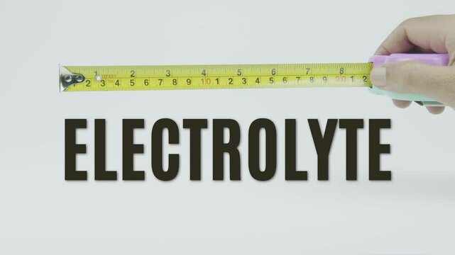 "Electrolyte" text with a tape measure on a white background, representing precision and accuracy in the measurement of essential minerals for bodily function