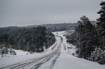Fototapeta premium winter snow-covered road in the forest covered with snow