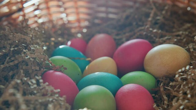 Colorful eggs in a basket surrounded by shredded paper for spring celebration