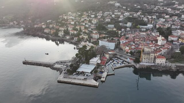 This panoramic drone footage provides a breathtaking aerial perspective of Lovran, featuring the Adriatic Sea, green hills, and charming coastal town.