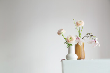 spring flowers in vases in white modern interior