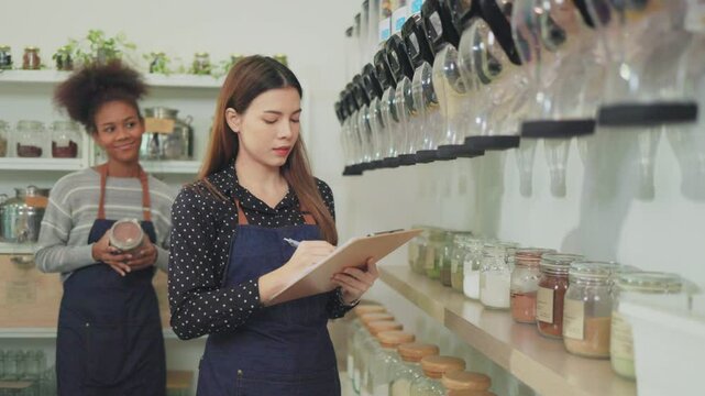 Young Woman Owner in Apron Selling Superfoods in Zero Waste Shop.  No plastic Conscious Minimalism Vegan  sustainable plastic free Lifestyle Concept.