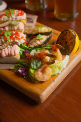 Deep fried battered snacks for beer on a wooden tray on the table