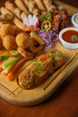 Deep fried battered snacks for beer on a wooden tray on the table