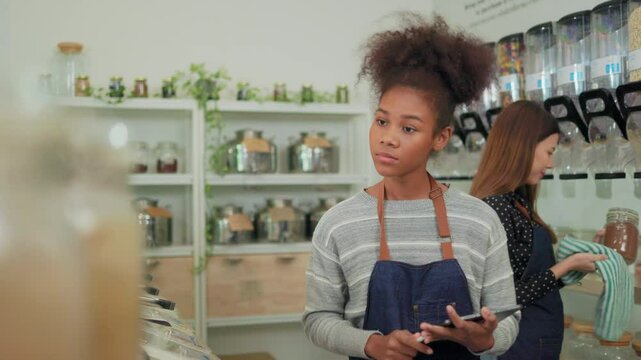 Young Woman Owner in Apron Selling Superfoods in Zero Waste Shop.  No plastic Conscious Minimalism Vegan  sustainable plastic free Lifestyle Concept.