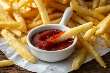 french fries and ketchup on wooden background