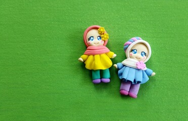 Beautiful clay doll, made of colorful modeling clay or plasticine. Beautiful girl doll with green background.