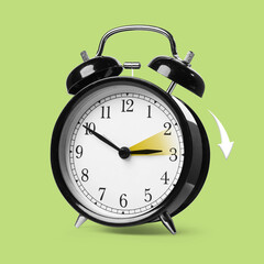 Daylight saving time. Black alarm clock on light green background. Highlighted area and arrow...