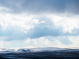 cloudy sky over field and snowy hills in Armenia