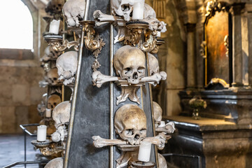 Large candlestick made of the human bones and skulls in Kostnice Sedlec Gothic chapel main hall in the Kutna Hora of Czech Republic