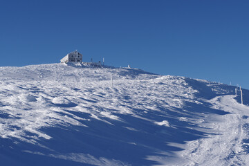 Picturesque sunny and snowy winter mountain landscape icy cold, strong wind and clear blue sky....