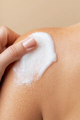 Fototapeta premium Close-up of a woman applying foaming exfoliating cream on skin