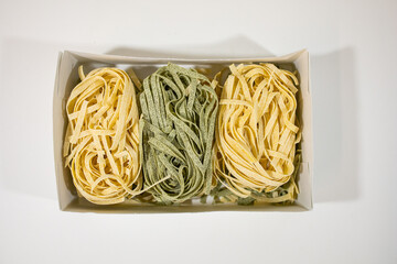 Twisted spaghetti in a box. Green spaghetti. Pasta dry. Italian food