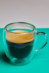 a double-walled glass mug with coffee on a table