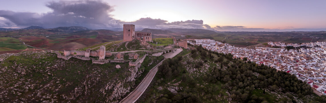 Aerial view of Castillo de la Estrella, Star castle in Teba Spain with large square keep dramatic colorful sunset sky