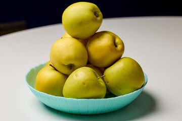 apples placed on a plate in the kitchen on a table