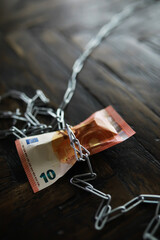 10 Euro Banknote Chained on Wooden Table - Concept of Financial Restriction and Security