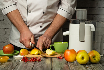 The chef skillfully slices bright apples and prepares healthy juice in a fancy kitchen. Refreshing fruit juice for breakfast made by the cook