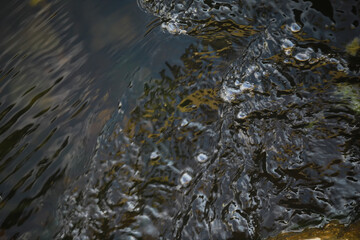 Close-Up of Dark Water Surface with Ripples and Reflections