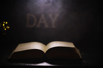 Open Book in Dim Light with Glowing DAY Text in Background