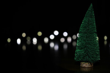Festive Miniature Christmas Tree with Bokeh Lights on Dark Background